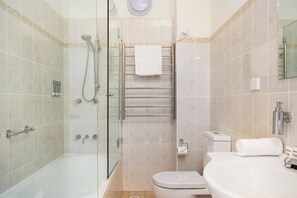 A bathroom with a glass-enclosed shower, a white toilet, and a sink with a mirror. - Cosy 2-Bed Apartment in the Heart of Strathfield (Strathfield)