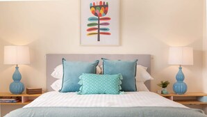 A bedroom with a bed, two bedside tables, and a wall-mounted lamp. - Cosy 2-Bed Apartment in the Heart of Strathfield (Strathfield)