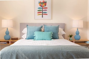 A bedroom with a bed, two bedside tables, and a wall-mounted lamp. - Cosy 2-Bed Apartment in the Heart of Strathfield (Strathfield)