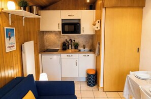 A compact kitchen with white cabinets, a microwave, and a sink. - Chamonix Center • Parking • Mont Blanc view (Chamonix-Mont-Blanc)