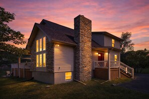 A two-story house with a stone chimney, large windows, and a front porch with a railing. - Ski retreat w/ 5BR, hot tub, huge game room, Pet Friendly (Albrightsville)