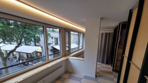 A hotel room with large windows, a checkered floor, and a small stool. - Green Marmot Capsule Hotel Zurich (Zürich)