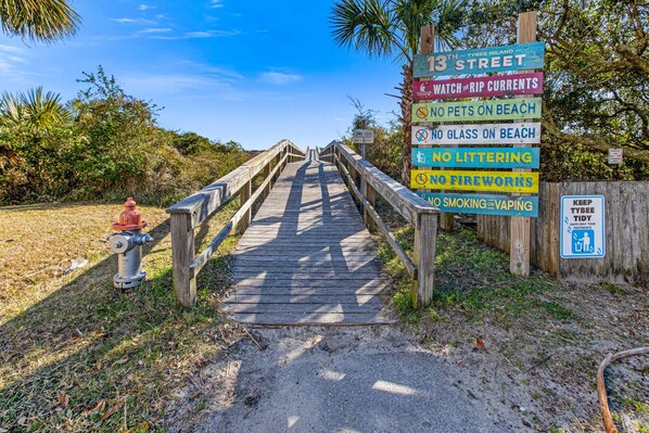 A wooden boardwalk leading to a beach area with multiple signs indicating rules such as no pets, no glass, no littering, no fireworks, and no smoking or vaping. - #1 Tybee Time | Oceanview & Steps from the Sand! (Tybee Island)