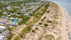 An aerial view of a coastal residential area with houses, a beach, and a pier. - Oceanview Retreat | Just Steps from the Beach (Tybee Island)