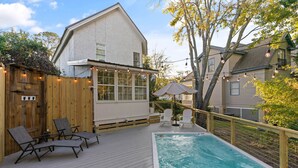 A wooden deck with a pool, lounge chairs, and a covered seating area. - Village Walk - 3 bedrooms, 2 1/2 bathrooms located next to the Village (Saint Simons Island)
