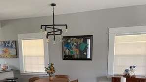En matplats med ett träbord och stolar, en hängande lampa och en världskarta på väggen.