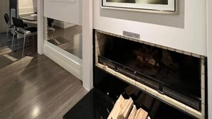 A modern interior with a fireplace, framed artwork, and a television. - Ettus Motel (Caxias do Sul)