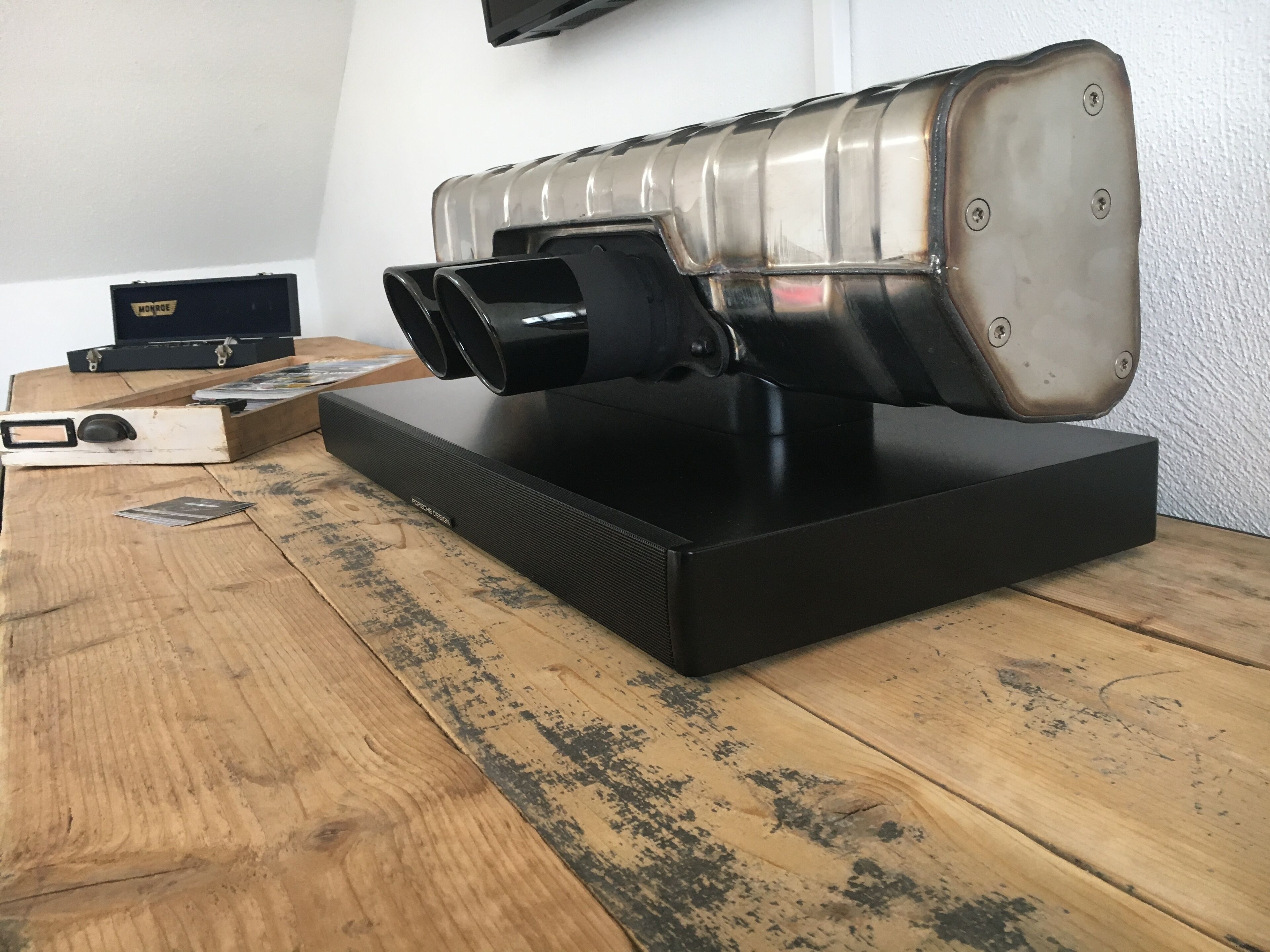 Ein Lautsprecher im Vintage-Stil auf einem Holztisch, im Hintergrund ein Fernsehgerät.