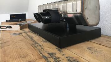 Ein Lautsprecher im Vintage-Stil auf einem Holztisch, im Hintergrund ein Fernsehgerät.