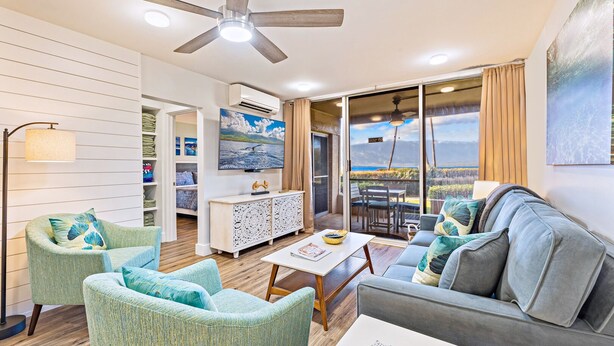 A modern living room with a ceiling fan, a dining area, and a view of the outdoors. - Amazing Ocean/Beach Front, Pool Side, Ground Floor Remodeled 2 Bdr 2 Bath Condo  (Kihei)