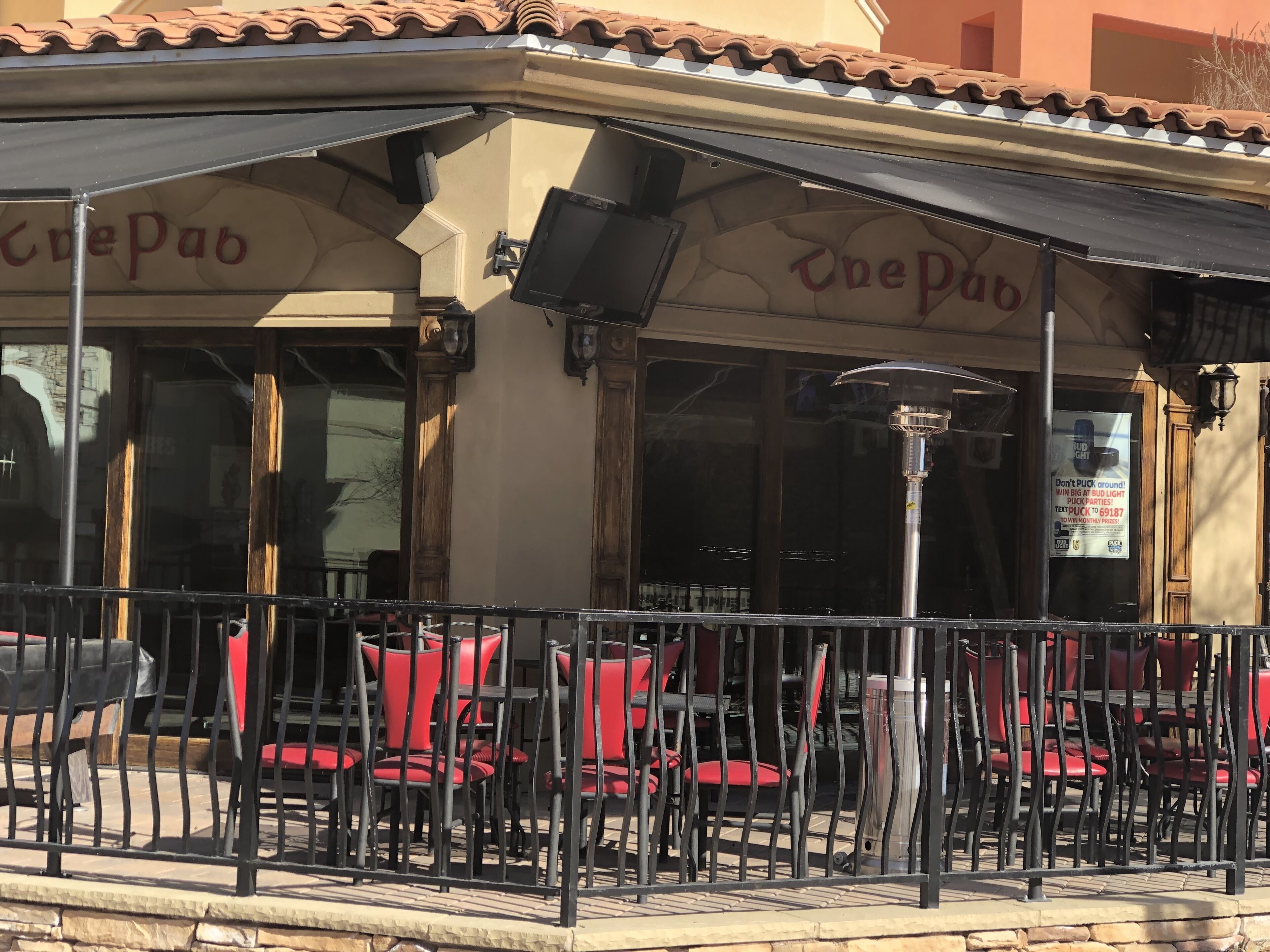 A cafe with outdoor seating, a tiled roof, and a sign reading "The Pub".