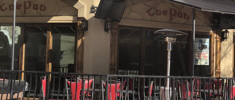 A cafe with outdoor seating, a tiled roof, and a sign reading "The Pub".