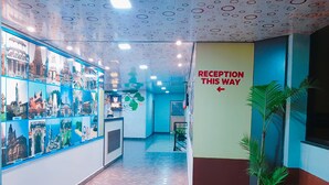 A reception area with a sign indicating the direction to the reception. - Rachana Palace (Mangaluru)