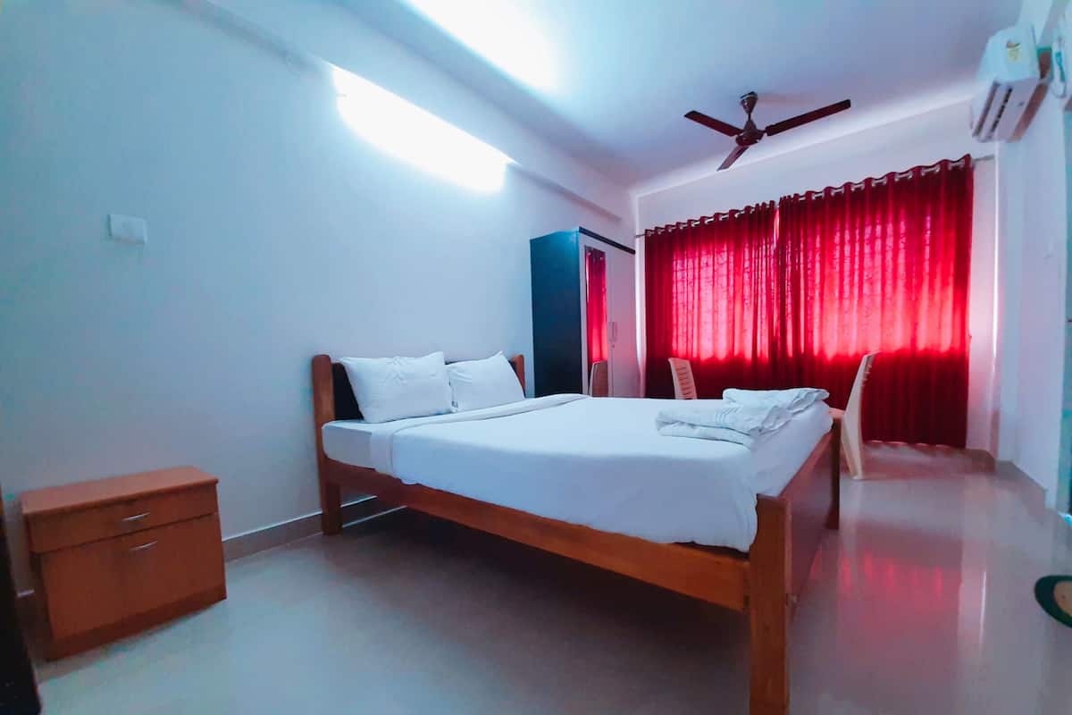 A bedroom with a bed, a nightstand, a wardrobe, and a ceiling fan.