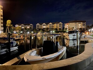 Boats docked at a serene marina with nearby buildings.
