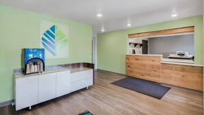 Una cocina moderna con cafetera integrada, un mueble de madera y un amplio ventanal.