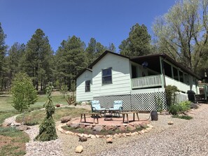 A single-story house with a porch, surrounded by a gravel driveway and a garden with rocks and small trees. - Hillside Cottage: Restful, quiet setting
Coconino County Permit # STR-26-0572 (Flagstaff)