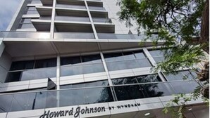 Un bâtiment moderne avec une façade en verre, sur lequel on peut clairement lire l’inscription « Howard Johnson ».