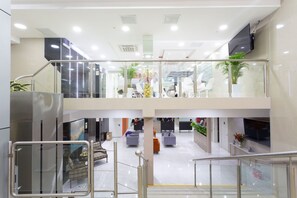 A multi-level indoor space with glass railings, seating areas, and a staircase. - Howard Johnson by Wyndham Lima Miraflores Art House (Lima)