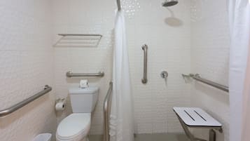 Een badkamer met toilet, douche en een handgreep.