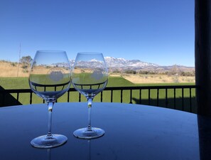 Due bicchieri da vino vuoti su un tavolo con vista su un paesaggio montuoso.