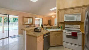 A modern kitchen with a dishwasher, oven, microwave, and granite countertop. - Spacious property in a quiet neighborhood, 30% discount for stays over 28 days (Lake Worth)