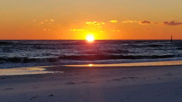 A sunset over the ocean with waves approaching the shore. - Steps to the gorgeous Mexico Beach! (Mexico Beach)