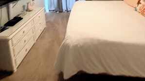 A bedroom with a bed, a dresser, a television, a ceiling fan, and a window with curtains. - Steps to the gorgeous Mexico Beach! (Mexico Beach)