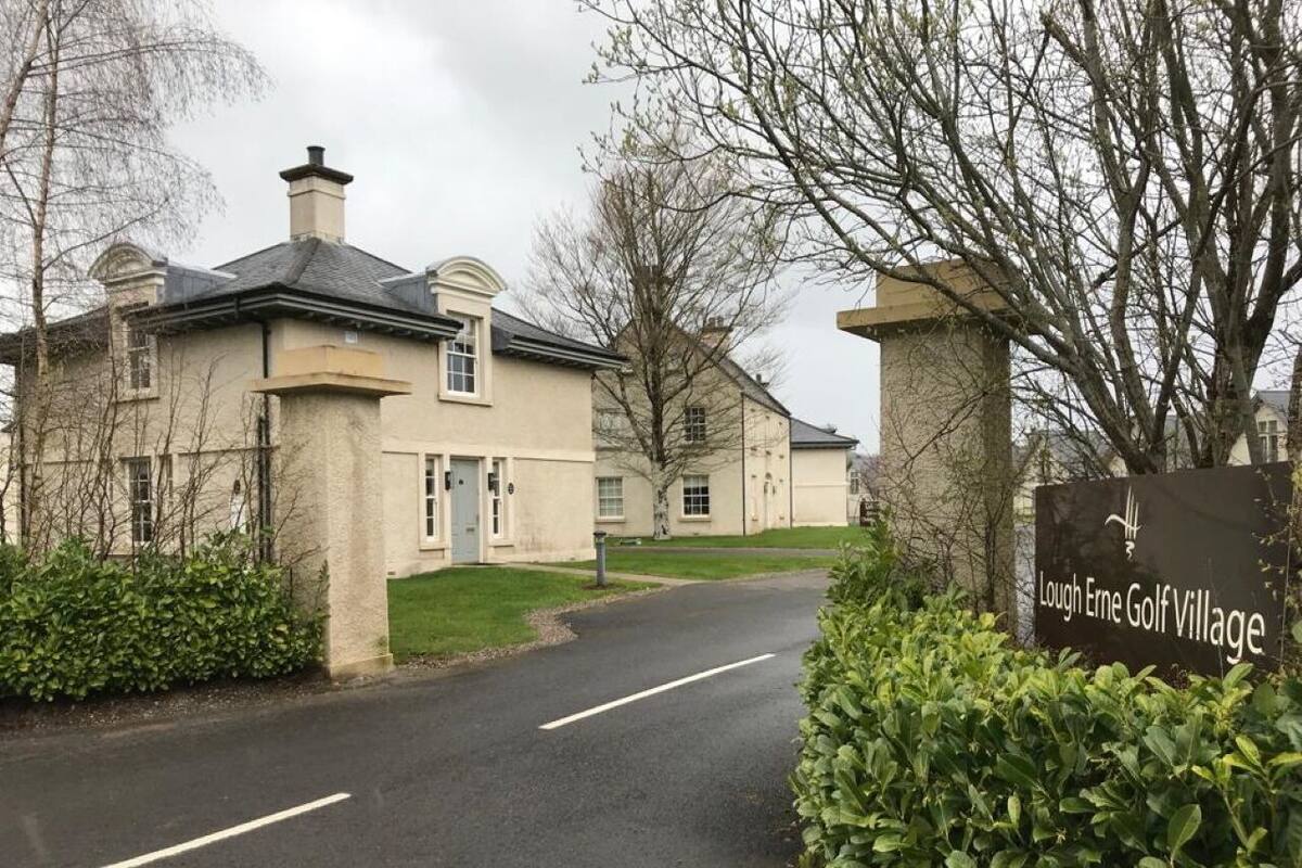 Eine Wohnstraße mit Häusern und einem Schild für Lough Erne Golf Village.
