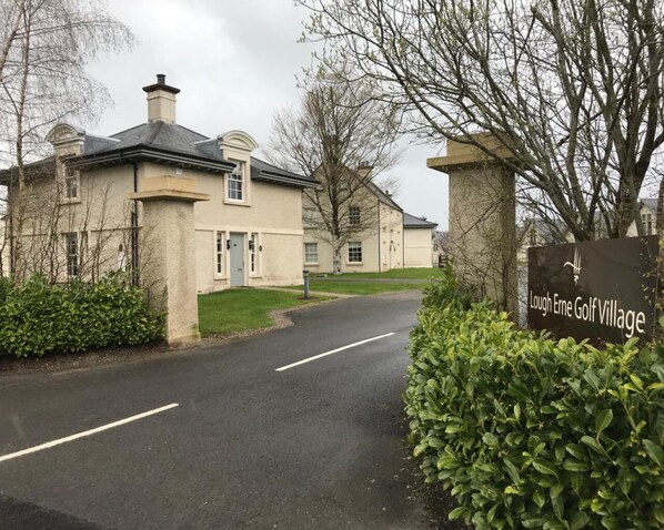 A residential street with houses and a sign for Lough Erne Golf Village. - The Gate Lodge (Ballyclare)