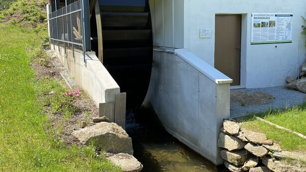 Ein Gebäude mit Holzfassade und einem Betonaufgang, der zu einem Wasserkanal führt.