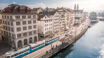 A tram line running alongside a canal with buildings on either side, including a hotel named 'HOTEL KRONE'.