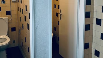 Une salle de bain avec des toilettes, un lavabo et une porte.