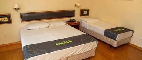 A hotel room with two beds, each with a 'boa' branded bedspread, a bedside table with a phone, and wall-mounted lamps.