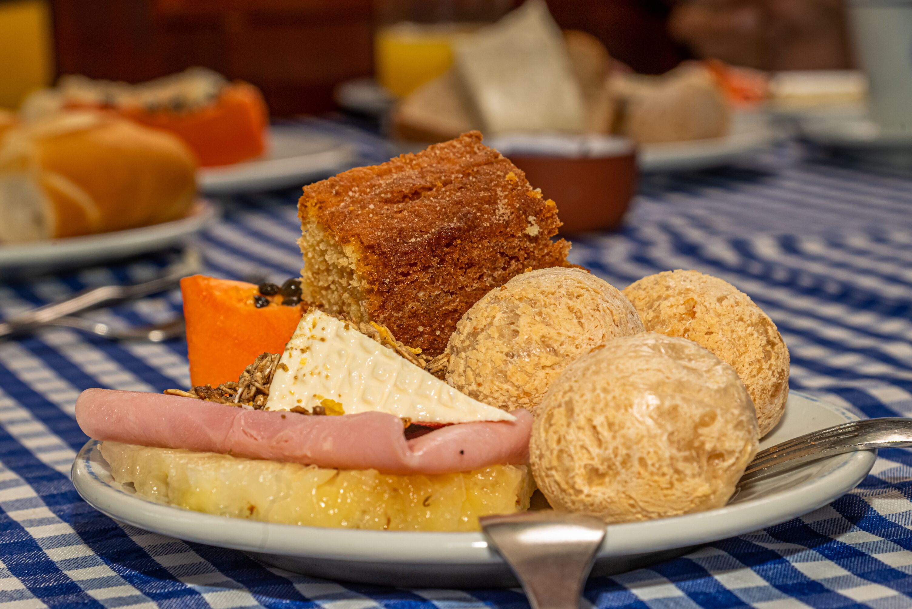 Ein Teller mit verschiedenen Frühstücksartikeln, darunter Brot, Käse und Schinken.