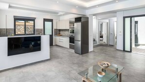 A modern kitchen with a built-in island, stainless steel appliances, and a glass dining table.