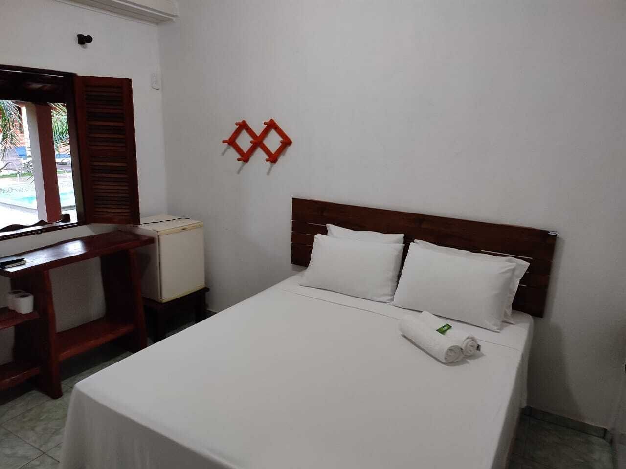 A hotel room with a bed, a desk, and a small table.