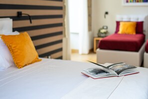 Habitació quàdruple Deluxe | Minibar, caixa forta a l'habitació, mobiliari individual i escriptori 