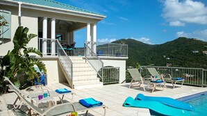 A resort with a pool area, lounge chairs, and a staircase leading to a covered deck. - Southern Breeze: Expansive Ocean Views! Amazing Sunrises! (St. John)