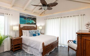 A bedroom with a bed, nightstands, a ceiling fan, a painting, and a window with curtains. - Southern Breeze: Expansive Ocean Views! Amazing Sunrises! (St. John)
