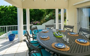 A covered outdoor dining area with a pool in the background. - Southern Breeze: Expansive Ocean Views! Amazing Sunrises! (St. John)