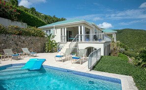 A pool area with lounge chairs and a swimming pool.