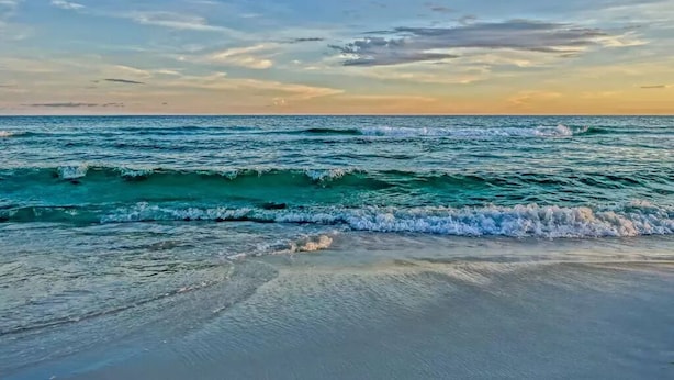 Una playa con olas y cielo despejado.