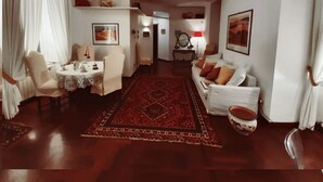 A spacious living room with a round coffee table, a sofa, and a dining area with chairs.