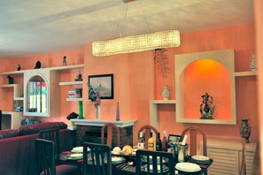 Enjoy meals with friends and family in this elegant dining area, featuring a long table, comfortable seating, and a warm atmosphere.