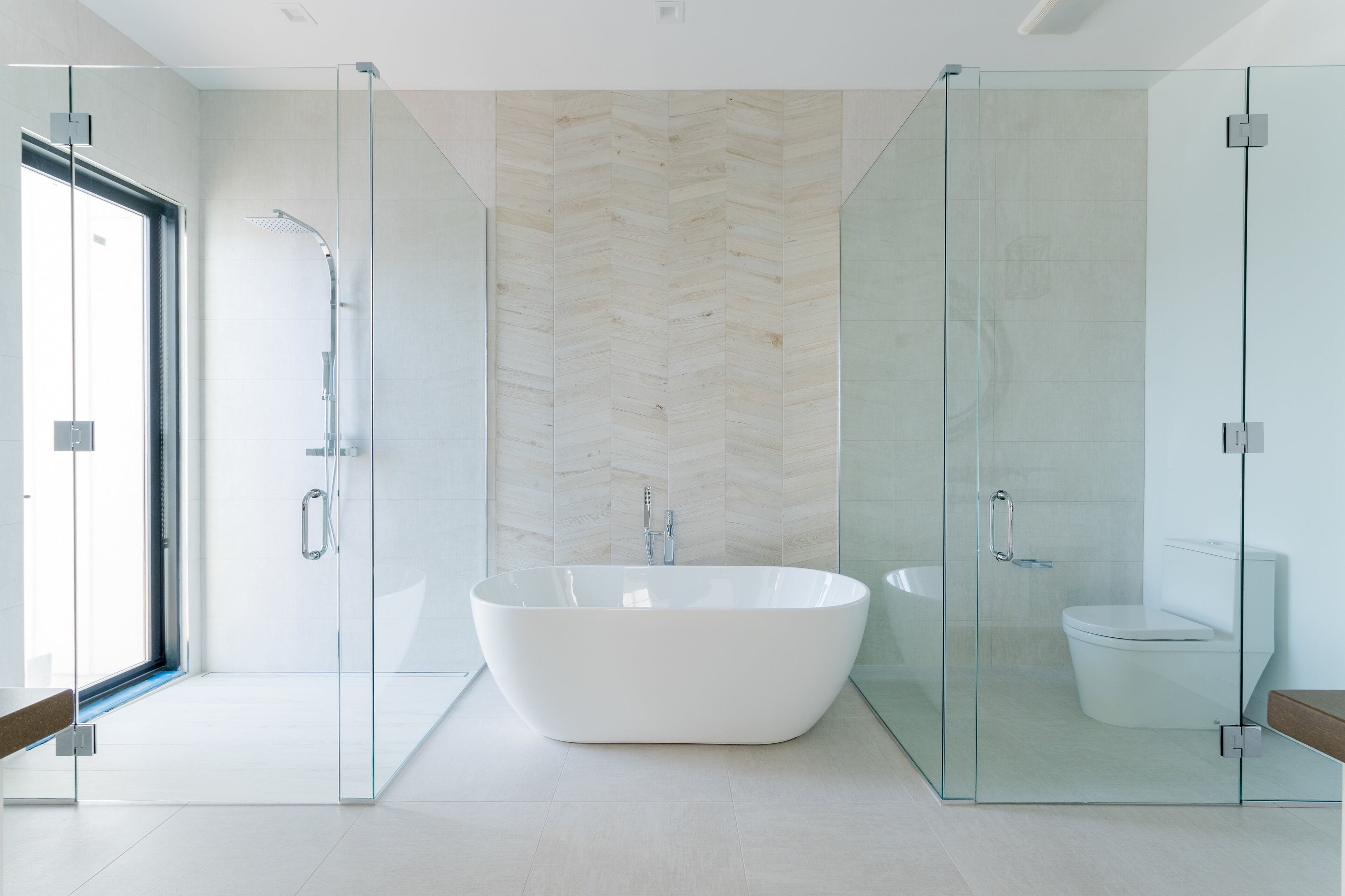 A modern bathroom with a freestanding bathtub, a glass-enclosed shower, and a toilet.