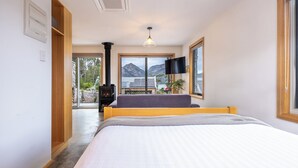 Une chambre à coucher avec un lit, une cheminée, une télévision et une vue sur les montagnes.