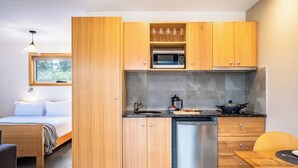 Une cuisine compacte avec des meubles en bois, un four à micro-ondes, un évier et un lave-vaisselle.
