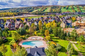 A residential area with houses, a swimming pool, and a hilly landscape in the background. - Luxury 3 Bedroom Blue Chalet. Entire House. 2 minute drive from the village (The Blue Mountains)