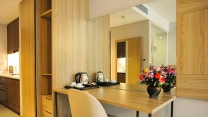 Una cocina moderna con armarios de madera, una mesa de comedor de madera, una silla blanca y un jarrón con flores.